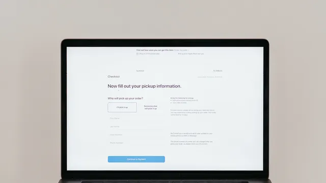 Aufgeklappter Laptop zeigt ein Onlineformular mit Eingabefeldern und einem Knopf zum Absenden